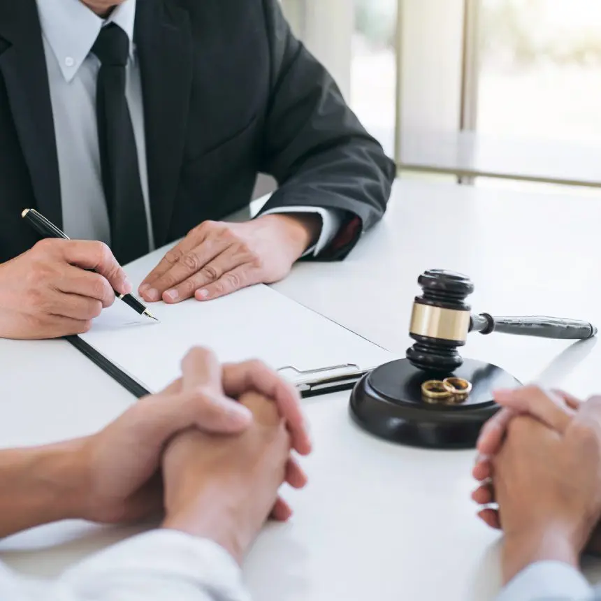 Lawyer signing divorce papers with couple.